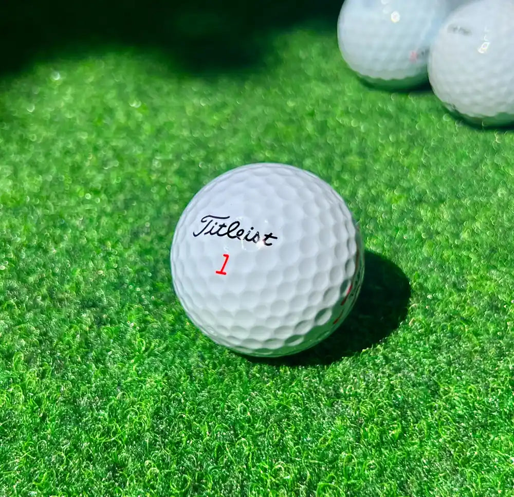 Titleist golfpallo lähikuvassa nurmella – EAGLE-laatu käytettynä